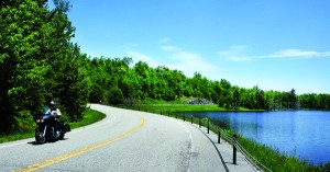 web-roadonwater Two-lane roads bring out the best in motorcycles, like this Harley Tour Glide, especially on a beautiful spring day.