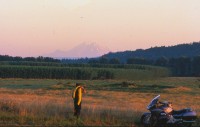The author turns his back on busy Route 2 to watch the sunset work its magic on mighty Tahoma (aka Mt. Rainier), 40 miles across the field.
