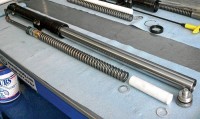 Fork with components laid out in orientation and order of assembly: D-Rod with bottom retaining bolt; GVE/Adapter; RT Fork Spring; PVC Spring Spacer with washers.