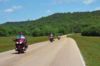 Riding through this lush, green corridor, you lose your sense of time and place. Progress is measured by simple, brown roadside mile-markers.